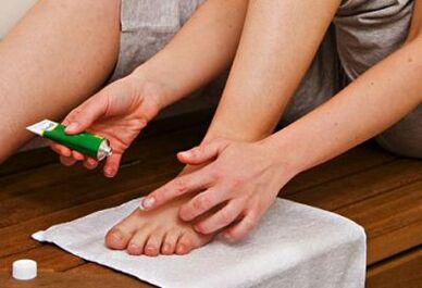 applying ointment to treat nail fungus
